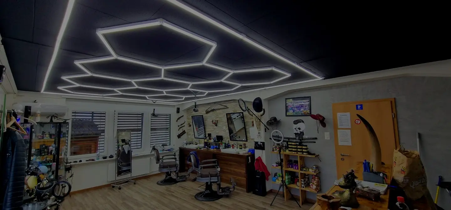 Der Herrensalon Shkrepi in Buchs: Barberstühle, Spiegelwand und Wabenlicht an der Decke